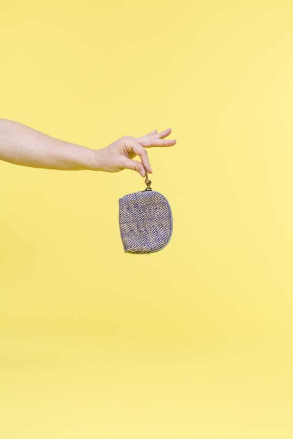 Kwooksta herringbone jute coin purse hanging from hand