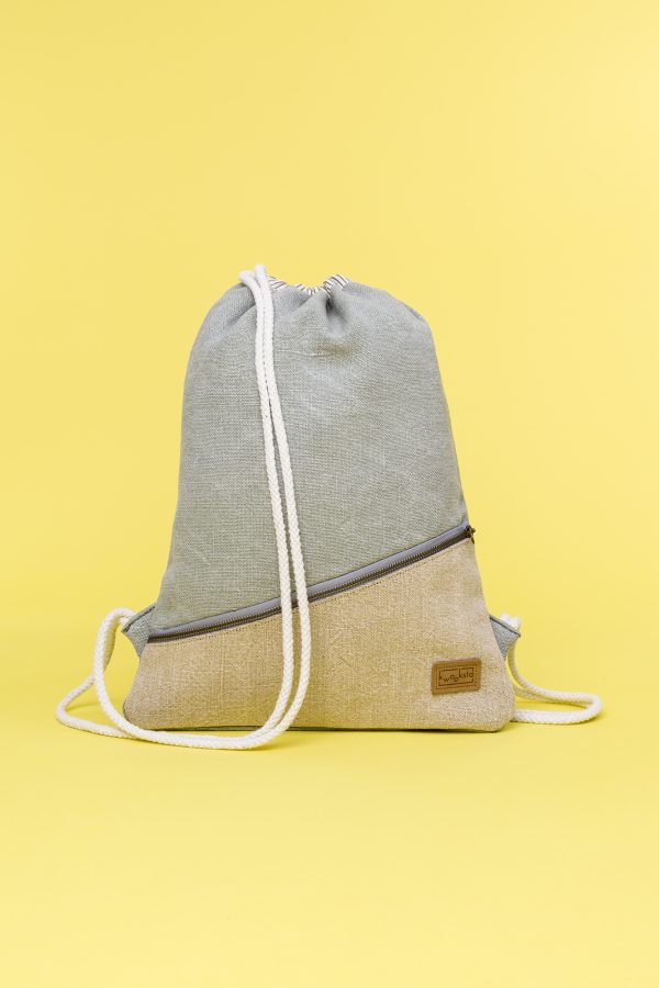 Kwooksta soft jute drawstring bag front view in green and natural with diagonal front zipper and white cotton straps